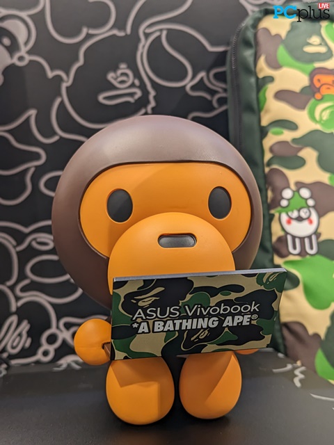 BAPE Baby Milo memegang laptop ASUS Vivobook jadi aksesoris yang unik